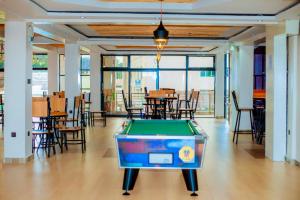 ein Billardtisch in einem Raum mit Tischen und Stühlen in der Unterkunft La Briella Hotel in Gisenyi