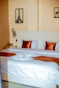 um quarto com uma grande cama branca com a torre eiffel em La Briella Hotel em Gisenyi