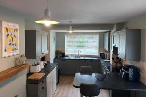 a kitchen with a sink and a counter top at 3 Bed House-Sleeps 5-Free Parking & Wi-Fi in Sketty +11 photos