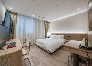 una habitación de hotel con una cama y un escritorio en 호텔 레이블 안산, en Chungang-yŏk