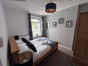 a bedroom with a bed and a window at 3 Bed House-Sleeps 5-Free Parking & Wi-Fi in Sketty