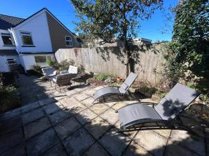 a group of chairs sitting in a backyard at 3 Bed House-Sleeps 5-Free Parking & Wi-Fi in Sketty