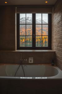 a bath tub in a room with a window at Hotel GRACE LA MARGNA ST MORITZ in St. Moritz