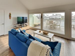 a living room with a blue couch and a tv at Sunset Water View in Padre Island