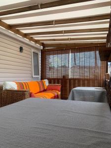 a room with two couches and a bed in it at MH365 2 chambres avec suite parentale et 2 salles de bain 40m2 dans camping 4 étoiles in Saint-Julien-en-Born