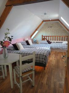 two beds in a attic room with a table and a table sidx sidx at les alouettes in Leschelles