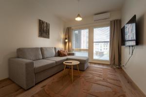 a living room with a couch and a table at Aurora suites with AIR CONDITIONING in Rovaniemi