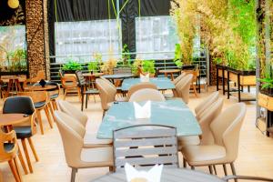eine Terrasse eines Restaurants mit Tischen und Stühlen in der Unterkunft La Briella Hotel in Gisenyi