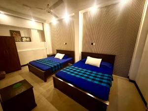 贝鲁沃勒Shehan Villa的有两张床和一张桌子的小房间