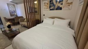 a bedroom with a white bed and a living room at Jtower residences in Mandaue City