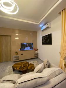 a living room with a couch and a tv at DLA Lux Studio in Ikota, Lagos in Lekki
