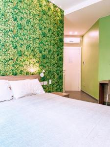 a bedroom with a bed and a green wall at Beverini Rooms in La Spezia