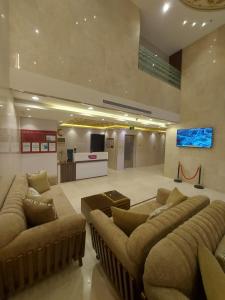 a lobby with couches and a tv in a room at Orvana Al Naseem Hotel in Makkah