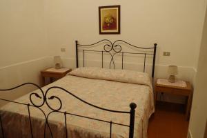 een slaapkamer met een bed en 2 nachtkastjes bij Villetta Casa Fiori - I GERANEI in San Savino