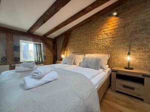 a bedroom with two beds and a brick wall at Siesta by Rentoom in Toruń