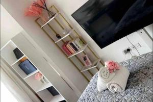 1 dormitorio con 1 cama con toallas y TV en Charming Dartford Apartment with 1 Bedroom, en Dartford