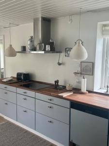 a kitchen with white cabinets and a counter top at Summerhouse Denmark in Tisvildeleje 700 m walk from beach in Tisvilde