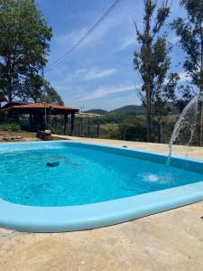 a swimming pool with a water fountain at Villa da Serra in Águas da Prata