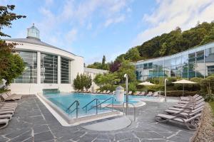 a swimming pool in front of a building at Dorint Parkhotel Jordanbad in Biberach an der Riß