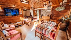 a living room with wooden walls and a table and chairs at Pousada Charm Canela in Canela