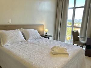 a bedroom with a large white bed with a window at Hotel Di Marco in Encantado