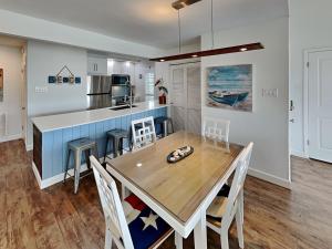 a dining room with a table and a kitchen at Sunset Water View in Padre Island