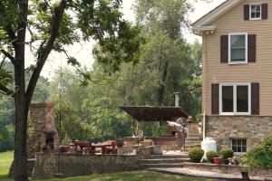 Un patio trasero con una pérgola al lado de una casa. en Hidden Valley Estate, en Harrisburg