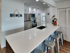 a kitchen with a white counter top and stools at Sunset Water View in Padre Island +31 photos