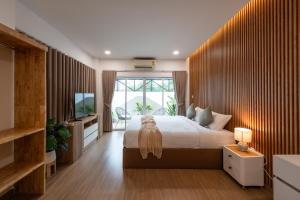 a bedroom with a large bed and a television at VivaDeva , Pool Villa In Nimman 4BR Near MAYA MALL in Chiang Mai +98 photos