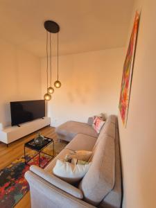 a living room with a couch and a tv at Heinsberg City Apartment - Stil trifft Farbe! in Heinsberg