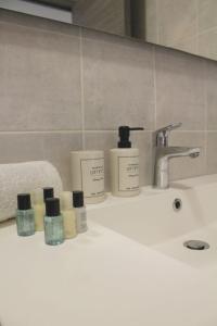 a bathroom sink with several bottles ofodorizers on it at Issam in Lyon