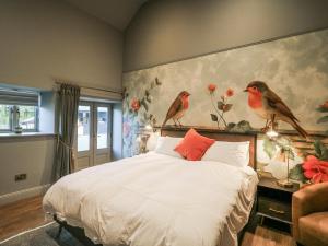 a bedroom with a bed with birds on the wall at Robins Rest at The Lodge in McGrathʼs Cross Roads