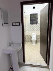a bathroom with a sink and a toilet at Grazioso Home Stay in Guwahati