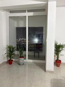a room with potted plants in front of a window at Grazioso Home Stay in Guwahati