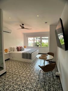 a bedroom with a bed and a table and a tv at Casa Verde Hotel in Santa Marta