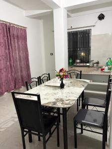 a dining room with a marble table and chairs at Grazioso Home Stay in Guwahati