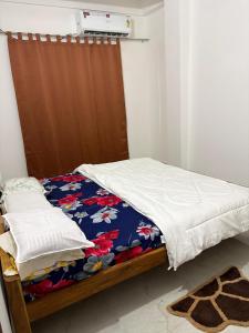 a bedroom with a bed with a blanket and a heater at Grazioso Home Stay in Guwahati +7 photos