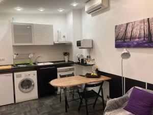 a small kitchen with a table and a washing machine at ASV Alojamiento in Pineda de Mar +62 photos