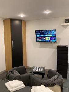 a living room with a couch and a tv on the wall at ASV Apartments in Pineda de Mar