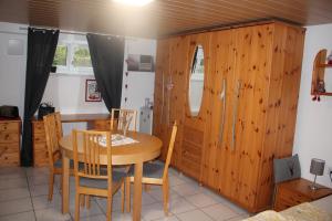 a dining room with a table and wooden cabinets at Schwarzwaldstube 2 Zimmer für Gäste in Vörstetten in Vörstetten