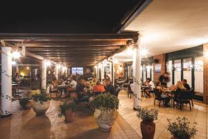 een groep mensen die aan tafels in een restaurant zitten bij Villaggio Turistico La Cecinella in Marina di Cecina