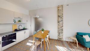 a kitchen and dining room with a table and a blue couch at Maison Magnifique Ernest Renan in Le Havre