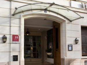 un accès à un bâtiment avec une arche au-dessus d'une porte dans l'établissement Hotel Daumesnil-Vincennes, à Vincennes