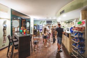 een groep mensen die bij een toonbank in een winkel staan bij Villaggio Turistico La Cecinella in Marina di Cecina