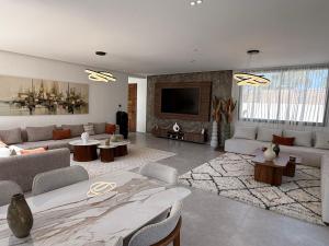 a large living room with couches and a flat screen tv at Villa B Marrakech Piscine Zéro vis-à-vis et chauffée in Marrakech