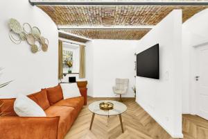 a living room with a couch and a tv at The Magnificent Urban Hideaway in Vinohrady +23 photos