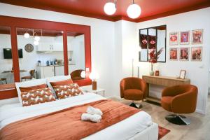 una camera da letto con un grande letto con due sedie e una scrivania di L'Écrin Rouge Escapade Romantique et Balnéo Privé a Bordeaux