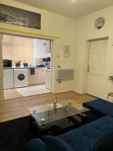 a living room with a blue couch and a kitchen at Good Heart in Birmingham +15 photos