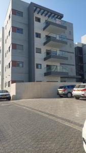 a parking lot with cars parked in front of a building at K Home 2 in Ma'ale Gamla