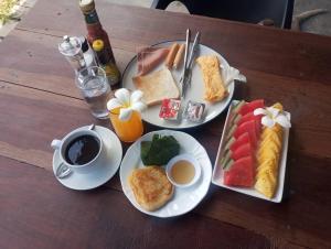 two plates of breakfast food on a wooden table at Mook Heaven Bungalow in Ko Mook